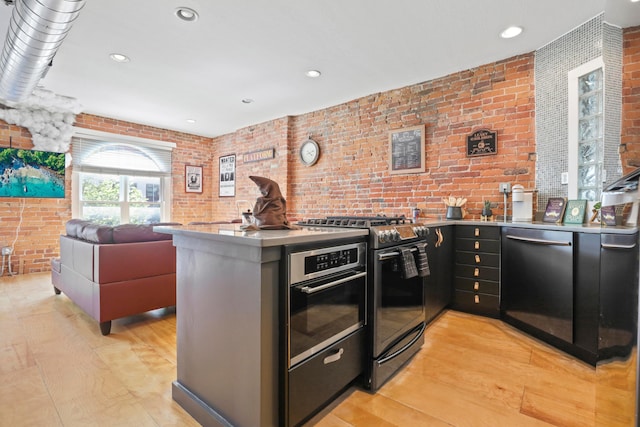 974 N High St Unit B, Columbus, OH 43201 - kitchen with appliances with stainless steel finishes, brick wall, a peninsula, recessed lighting, and light wood-style floors