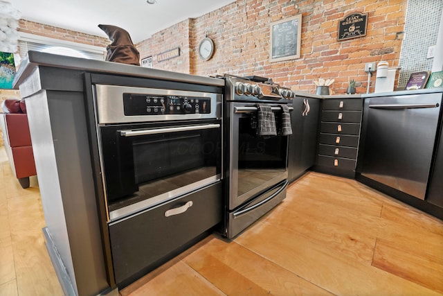 974 N High St Unit B, Columbus, OH 43201 - kitchen with appliances with stainless steel finishes, brick wall, and light wood finished floors