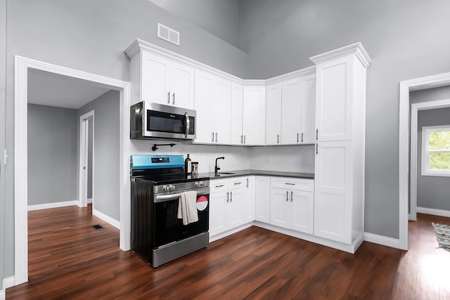 172 Jefferson St, Mount Sterling, OH 43143 - kitchen featuring stainless steel appliances, dark wood finished floors, white cabinets, and dark countertops