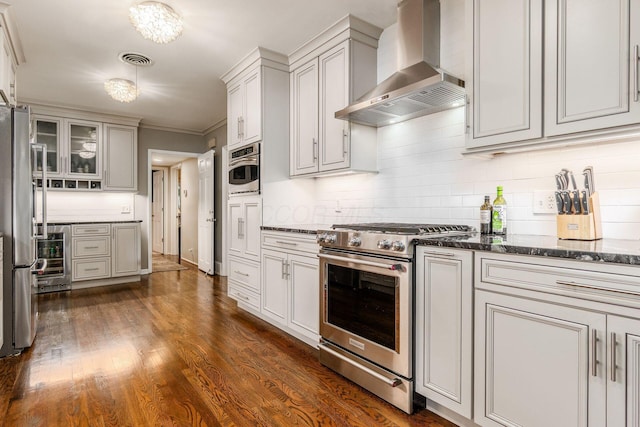 207 Ashbourne Rd, Bexley, OH 43209 - kitchen with appliances with stainless steel finishes, wall chimney exhaust hood, tasteful backsplash, dark wood-style floors, and ornamental molding