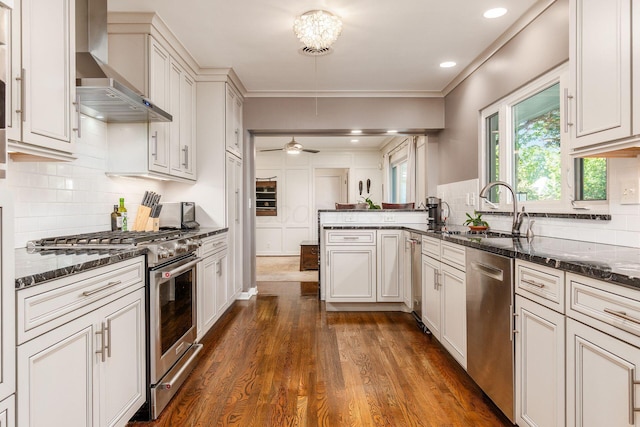 207 Ashbourne Rd, Bexley, OH 43209 - kitchen featuring stainless steel appliances, wall chimney exhaust hood, a peninsula, dark wood-style floors, and tasteful backsplash