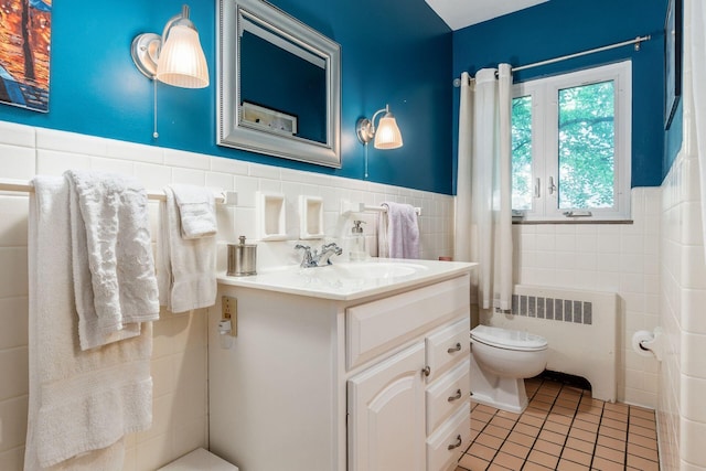 207 Ashbourne Rd, Bexley, OH 43209 - bathroom featuring radiator heating unit, tile walls, tile patterned floors, vanity, and wainscoting
