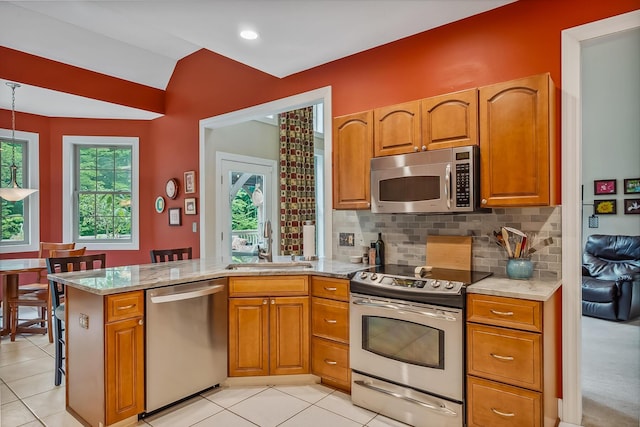 1554 Hanover Rd, Delaware, OH 43015 - kitchen with stainless steel appliances, a peninsula, backsplash, brown cabinetry, and lofted ceiling