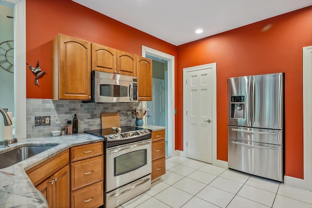1554 Hanover Rd, Delaware, OH 43015 - kitchen featuring appliances with stainless steel finishes, light stone counters, tasteful backsplash, and brown cabinetry
