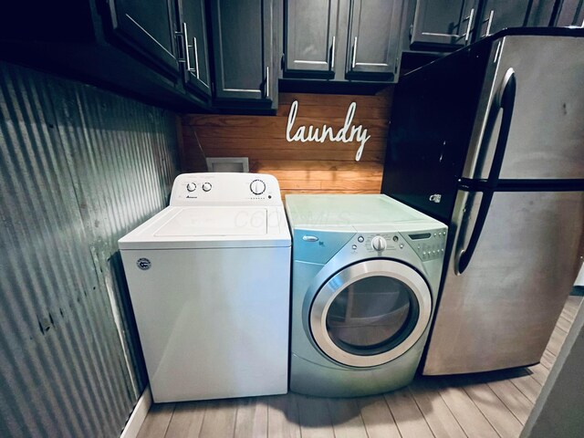 332 Baroness Way, Columbus, OH 43230 - laundry area with independent washer and dryer, cabinet space, and light wood-style flooring