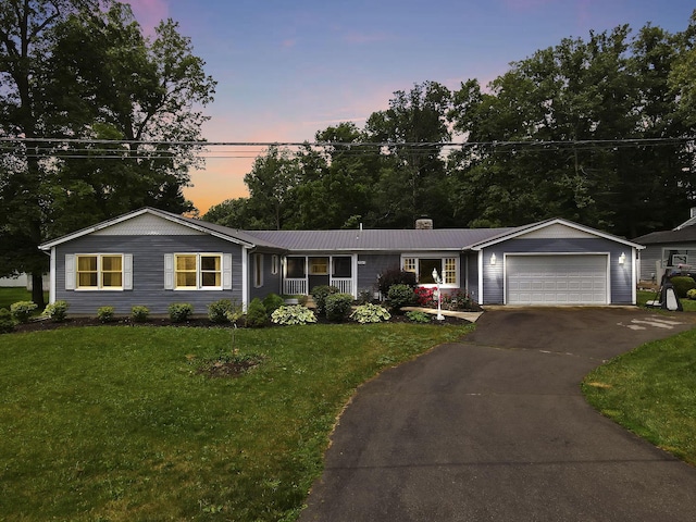 9840 Buckeye Dr, Huntsville, OH 43324 - ranch-style home with a chimney, a front lawn, asphalt driveway, an attached garage, and a metal roof