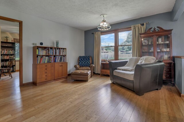 9840 Buckeye Dr, Huntsville, OH 43324 - living area with light wood-style floors, a textured ceiling, and a chandelier