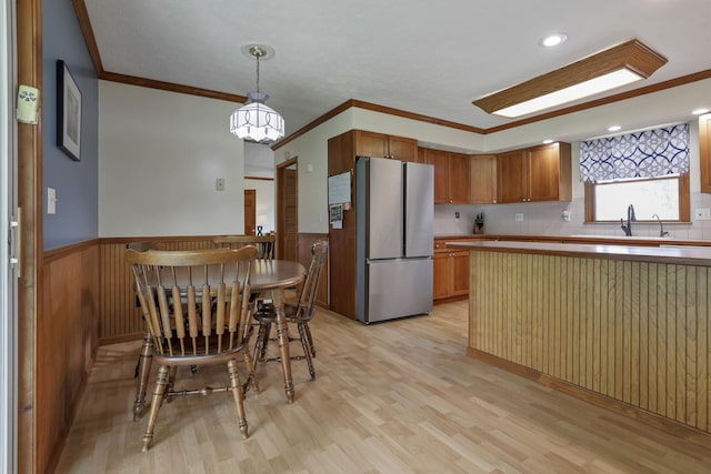 9840 Buckeye Dr, Huntsville, OH 43324 - kitchen with freestanding refrigerator, a wainscoted wall, light wood-style floors, crown molding, and a chandelier