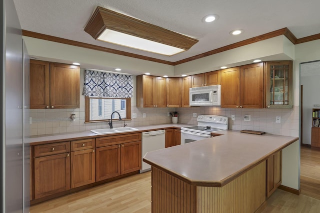 9840 Buckeye Dr, Huntsville, OH 43324 - kitchen with white appliances, ornamental molding, a peninsula, light wood-style flooring, and brown cabinetry