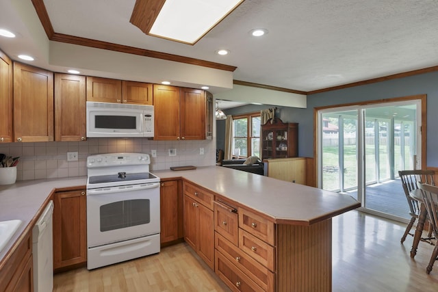 9840 Buckeye Dr, Huntsville, OH 43324 - kitchen with white appliances, crown molding, light wood-type flooring, a peninsula, and tasteful backsplash