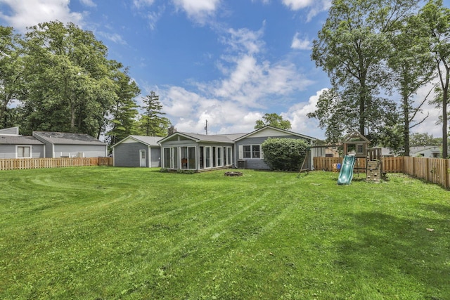 9840 Buckeye Dr, Huntsville, OH 43324 - fenced backyard featuring a playground and a sunroom