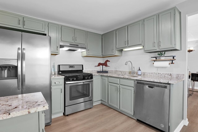 645 E 11th Ave Unit 643, Columbus, OH 43211 - kitchen featuring appliances with stainless steel finishes, under cabinet range hood, light wood-style floors, and light stone countertops