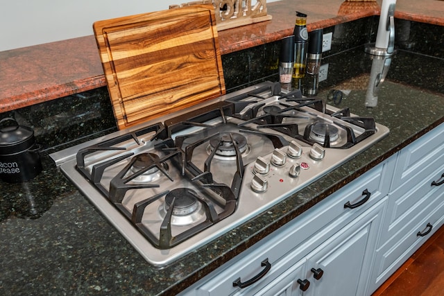 9950 Stonemead Way, Dayton, OH 45458 - kitchen view of gas cooktop, dark stone counters, and decorative backsplash