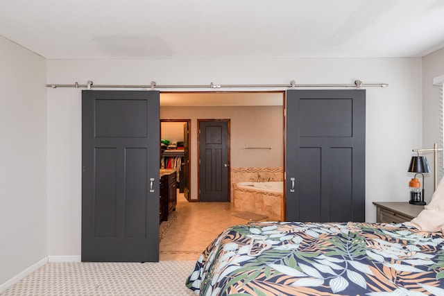 9950 Stonemead Way, Dayton, OH 45458 - bedroom with a barn door, ensuite bathroom, and light colored carpet