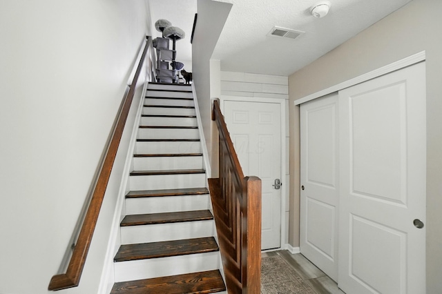5346 Calypso Cascades Dr, Dublin, OH 43016 - stairway with wood finished floors and a textured ceiling