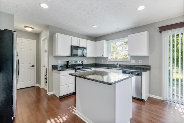 7341 Clancy Way, Westerville, OH 43082 - kitchen with appliances with stainless steel finishes, dark wood-style floors, white cabinetry, dark stone counters, and a center island