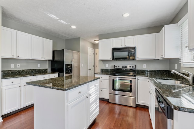 7341 Clancy Way, Westerville, OH 43082 - kitchen featuring appliances with stainless steel finishes, a kitchen island, dark wood finished floors, white cabinetry, and recessed lighting