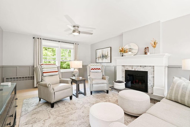 405 N Union St, Galion, OH 44833 - living area with a ceiling fan, wood finished floors, a glass covered fireplace, and a wainscoted wall