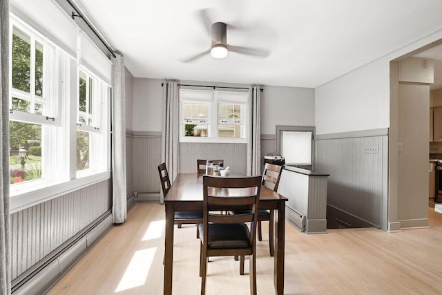 405 N Union St, Galion, OH 44833 - dining room with wainscoting, a baseboard heating unit, light wood-style floors, and ceiling fan