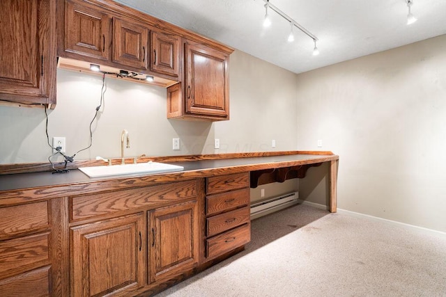 405 N Union St, Galion, OH 44833 - kitchen featuring track lighting, a baseboard heating unit, brown cabinets, carpet, and built in desk