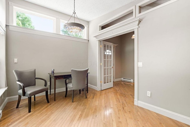 405 N Union St, Galion, OH 44833 - dining space featuring a baseboard heating unit, light wood finished floors, plenty of natural light, and a textured ceiling