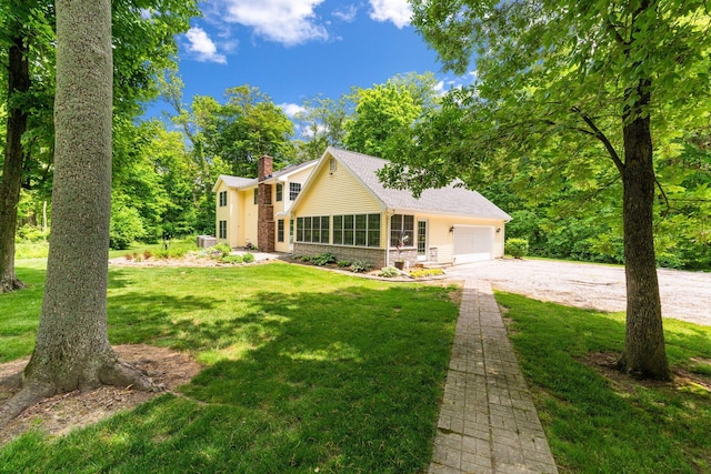 4563 Donithen Rd, Marion, OH 43302 - view of front facade with a chimney, a front lawn, brick siding, and driveway