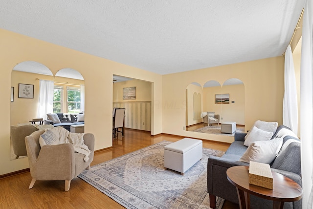 9 Intermeadows Way, Powell, OH 43065 - living area featuring arched walkways, wood finished floors, and a textured ceiling