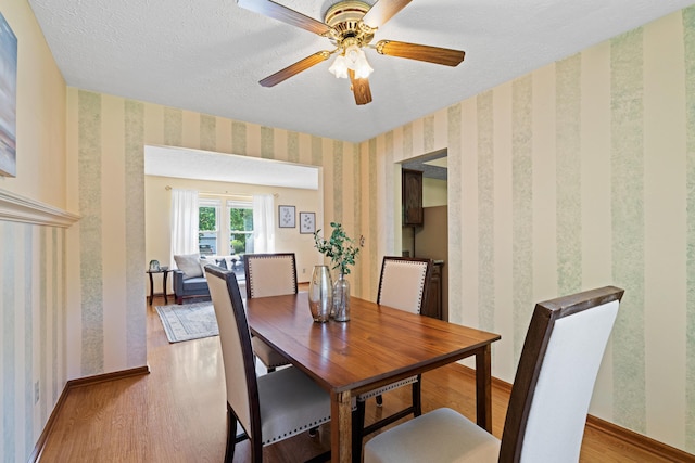 9 Intermeadows Way, Powell, OH 43065 - dining area featuring wood finished floors, wallpapered walls, a textured ceiling, and ceiling fan