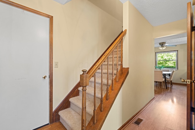 9 Intermeadows Way, Powell, OH 43065 - staircase featuring wood finished floors, a textured ceiling, and ceiling fan