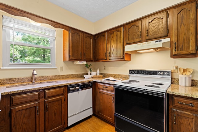 9 Intermeadows Way, Powell, OH 43065 - kitchen featuring range with electric stovetop, under cabinet range hood, white dishwasher, light wood-style floors, and a textured ceiling
