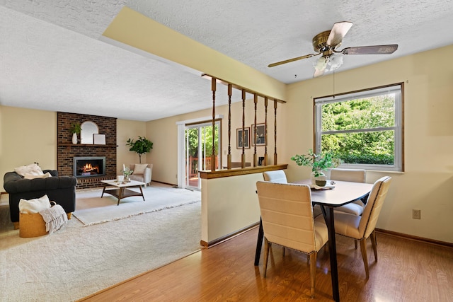 9 Intermeadows Way, Powell, OH 43065 - dining space featuring a textured ceiling, wood finished floors, a fireplace, and ceiling fan