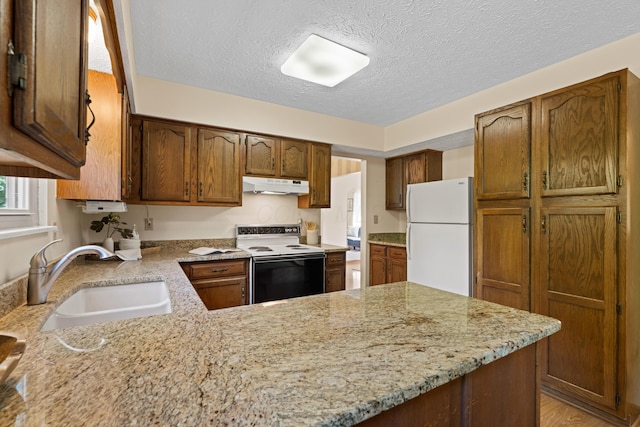 9 Intermeadows Way, Powell, OH 43065 - kitchen featuring white appliances, under cabinet range hood, a textured ceiling, a peninsula, and light stone counters