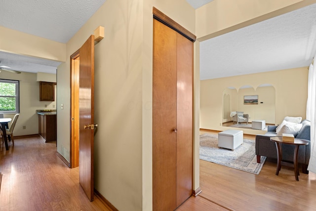 9 Intermeadows Way, Powell, OH 43065 - corridor featuring arched walkways, light wood-style floors, and a textured ceiling