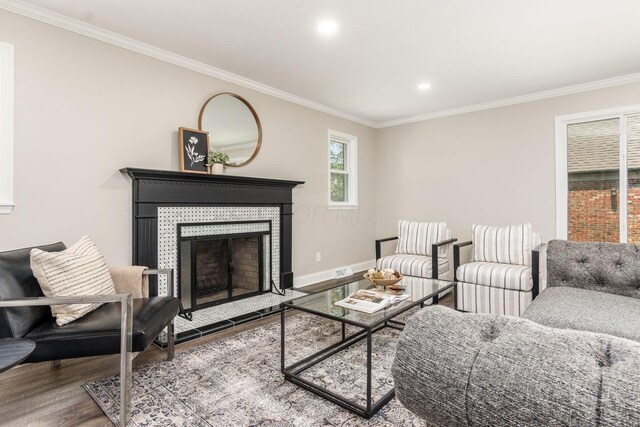 1120 Fairway Blvd, Columbus, OH 43213 - living area featuring a tiled fireplace, wood finished floors, crown molding, and recessed lighting