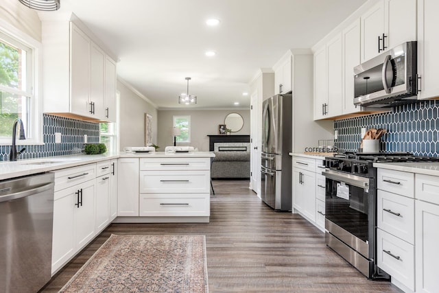 1120 Fairway Blvd, Columbus, OH 43213 - kitchen featuring stainless steel appliances, light countertops, wood finished floors, white cabinetry, and crown molding