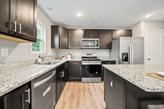 1364 Robinof Dr, Grove City, OH 43123 - kitchen featuring appliances with stainless steel finishes, light wood finished floors, light stone countertops, and dark brown cabinets
