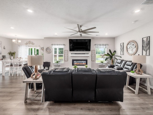 326 Mannaseh Dr W, Granville, OH 43023 - living area with ceiling fan, a chandelier, wood finished floors, a glass covered fireplace, and recessed lighting