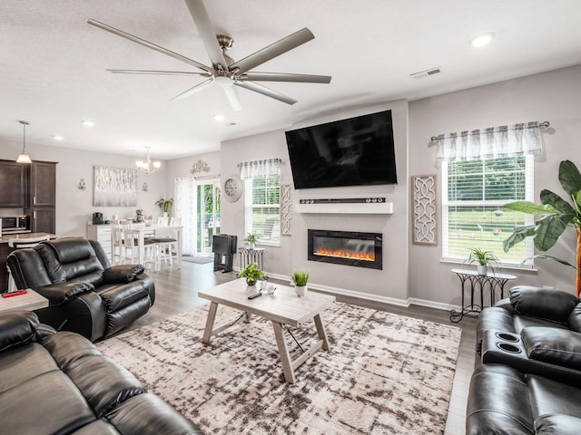 326 Mannaseh Dr W, Granville, OH 43023 - living area featuring a ceiling fan, recessed lighting, wood finished floors, a chandelier, and a glass covered fireplace