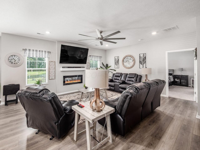 326 Mannaseh Dr W, Granville, OH 43023 - living area with a ceiling fan, wood finished floors, a glass covered fireplace, recessed lighting, and a textured ceiling
