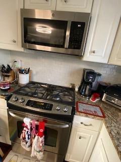 5510 Coopers Hawk Cir, Dublin, OH 43016 - kitchen featuring appliances with stainless steel finishes, white cabinets, and decorative backsplash