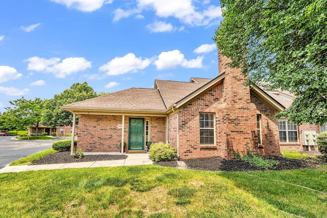 9460 Clermont Cir, Powell, OH 43065 - view of front facade featuring a front lawn, brick siding, a chimney, and a shingled roof