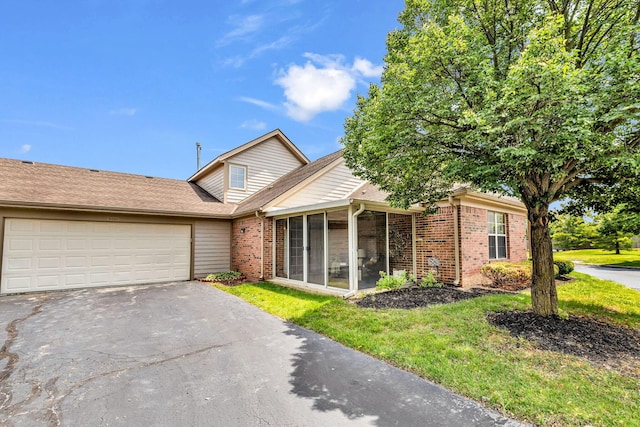 9460 Clermont Cir, Powell, OH 43065 - view of front of home featuring brick siding, a sunroom, driveway, an attached garage, and a front lawn