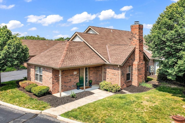 9460 Clermont Cir, Powell, OH 43065 - view of front of house with roof with shingles, a chimney, a front lawn, and brick siding