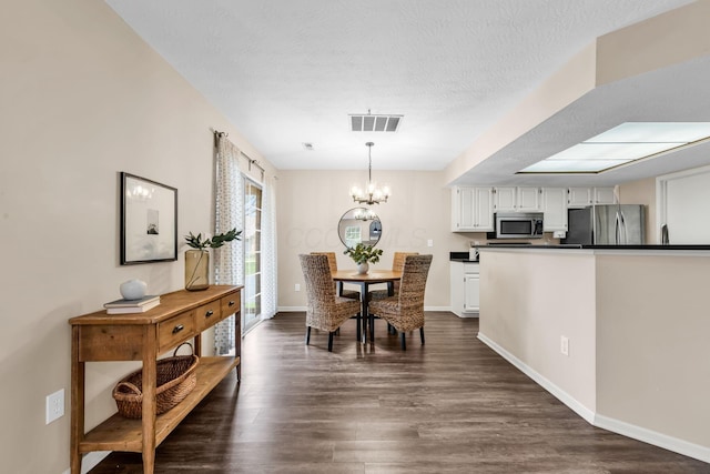 9460 Clermont Cir, Powell, OH 43065 - dining space featuring a chandelier, dark wood-style flooring, and a textured ceiling