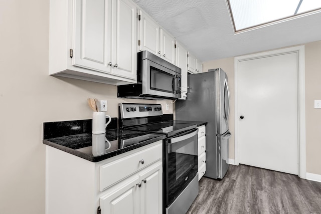 9460 Clermont Cir, Powell, OH 43065 - kitchen featuring stainless steel appliances, wood finished floors, white cabinetry, and dark countertops