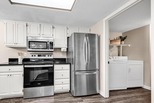9460 Clermont Cir, Powell, OH 43065 - kitchen with stainless steel appliances, separate washer and dryer, dark countertops, white cabinetry, and a textured ceiling