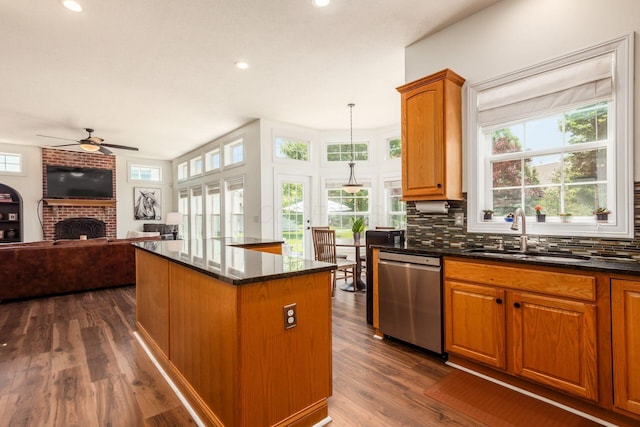 5866 Morganwood Sq, Hilliard, OH 43026 - kitchen featuring stainless steel dishwasher, a ceiling fan, a fireplace, dark stone counters, and tasteful backsplash