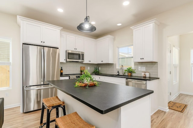 605 Frebis Ave, Columbus, OH 43206 - kitchen with stainless steel appliances, dark countertops, light wood finished floors, white cabinetry, and recessed lighting