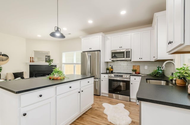 605 Frebis Ave, Columbus, OH 43206 - kitchen featuring appliances with stainless steel finishes, dark countertops, white cabinetry, tasteful backsplash, and recessed lighting
