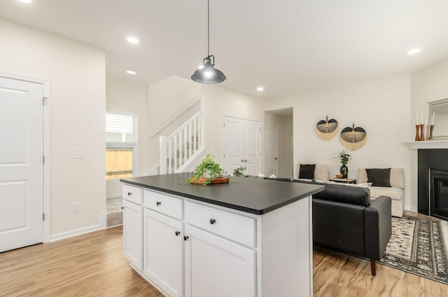 605 Frebis Ave, Columbus, OH 43206 - kitchen with dark countertops, light wood-style floors, white cabinets, a kitchen island, and recessed lighting